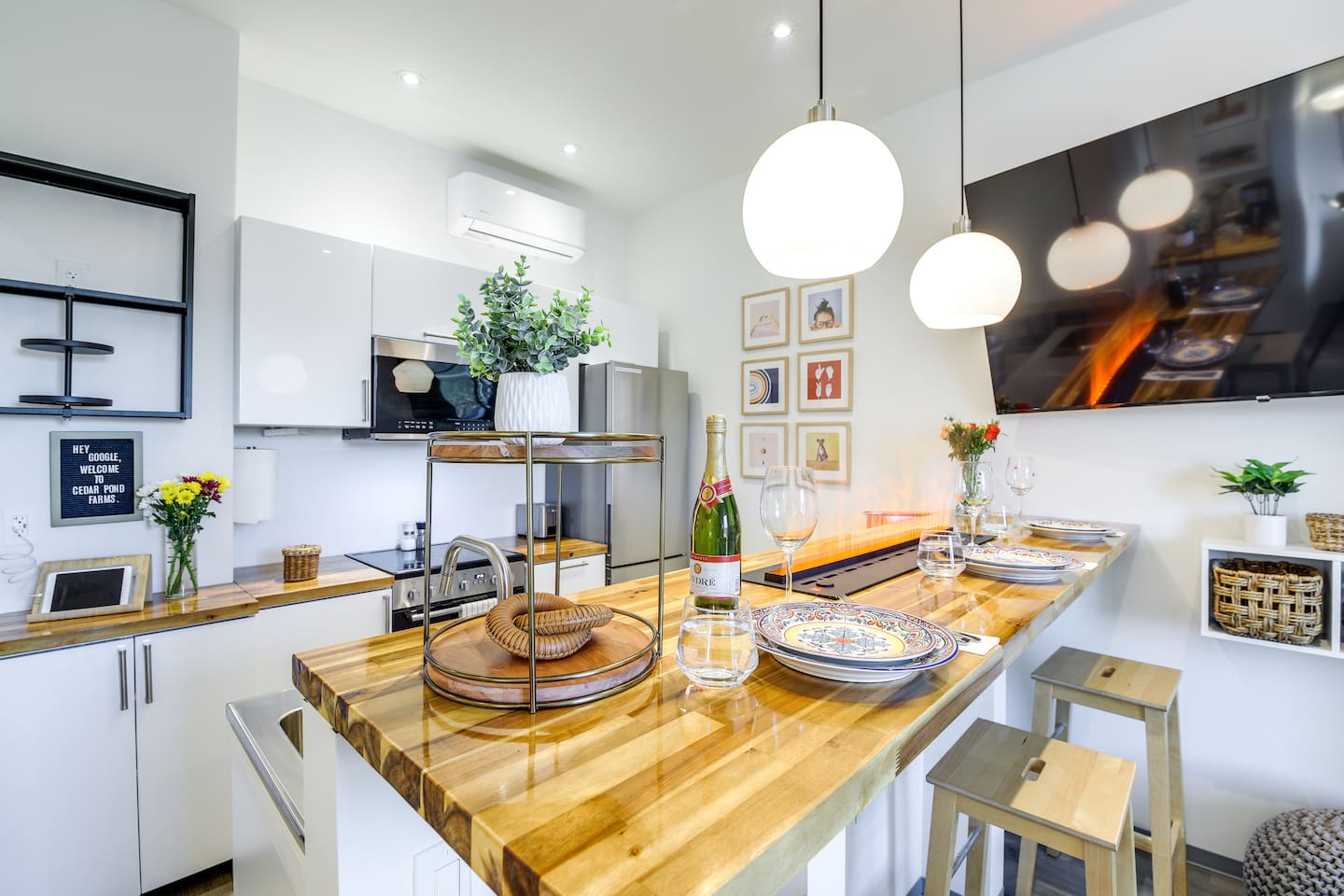 Bright modern kitchen with breakfast bar, pendant lights, and stylish dining setup